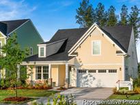 Charming two-story home with a covered front porch, attached two-car garage, and manicured lawn at 1022 House Finch Ave # Cc3-22-10P, Ravenel, SC 29470