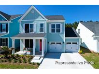 Charming two-story home with a covered front porch and an attached two-car garage at 1044 Northern Flicker Dr # Cc3-18-2P, Ravenel, SC 29470