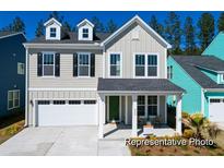 Charming two-story home featuring board and batten and lap siding, a welcoming front porch, and an attached garage at 1050 Marsh Harrier Dr # Cc3-15-3P, Ravenel, SC 29470