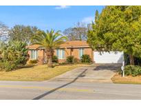 Charming single-story brick home with a well-manicured lawn and mature landscaping at 1060 Yeamans Hall Rd, Hanahan, SC 29410