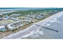 Panoramic aerial view of a beachfront resort featuring a long fishing pier and oceanfront pool at 1300 Ocean Blvd # 232, Isle of Palms, SC 29451