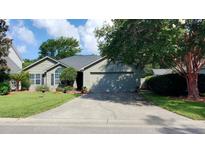 Charming one-story home featuring a well-maintained lawn, mature trees, and an attached two car garage at 1310 Pilsdon Crest, Mount Pleasant, SC 29464