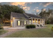 Charming home with a covered porch, landscaped yard, and brick pathway leading to the entrance at 1365 Whippoorwill Farm Rd, Johns Island, SC 29455