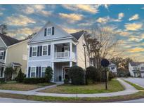 Charming two-story home featuring a welcoming front porch and classic architectural details under a cloudy sky at 1749 Towne St, Johns Island, SC 29455