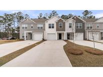 Charming townhomes featuring varied siding colors, attached garages, and concrete driveways lined by well manicured lawns at 205 Cozy Brook Ct, Summerville, SC 29486