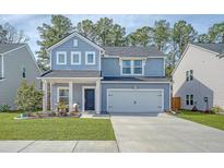 Charming two-story home with a well-manicured lawn and inviting front porch at 215 Camellia Bloom Dr, Moncks Corner, SC 29461