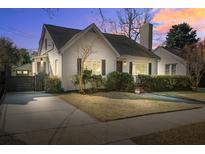 Charming white brick home with a manicured front yard and inviting curb appeal at dusk at 229 Gordon St, Charleston, SC 29403