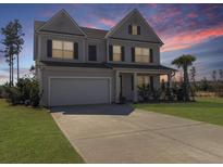 Charming two-story home with a well-manicured lawn, a two-car garage and a beautiful dusk sky at 265 Celestial Blvd, Summerville, SC 29486