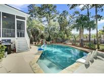 Inviting backyard pool features a waterfall, basketball hoop, and plenty of lounge space for relaxation and entertainment at 2745 Oak Manor Dr, Mount Pleasant, SC 29466