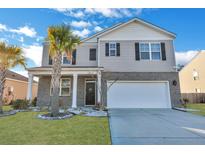 Charming home featuring a two-car garage, complemented by palm trees and meticulous landscaping at 302 Willow Pointe Cir, Summerville, SC 29486