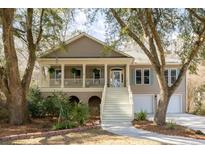 Charming two-story home featuring a welcoming front porch, landscaped yard, and attached two-car garage at 3021 Rushland Mews, Johns Island, SC 29455