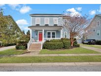 Charming two-story home featuring a red front door, inviting porch, and manicured landscaping on a sunny day at 3676 Shutesbury St, Mount Pleasant, SC 29466