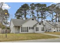 Charming one-story home with grey siding and dark shutters surrounded by mature trees at 4064 Bonaparte Dr, North Charleston, SC 29418