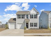 Charming two-story home featuring a two-car garage, a well-manicured lawn, and classic architectural details at 464 Fox Sparrow Ct, Summerville, SC 29486