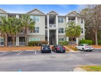 Three-story condominium building with palm trees, stairs, and parking at 700 Daniel Ellis Dr # 14206, Charleston, SC 29412