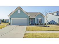 Charming single-story home with blue siding, well-manicured lawn, and a two-car garage on a sunny day at 127 Garden Gate Way, Summerville, SC 29486