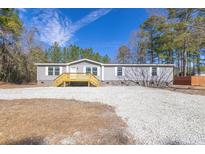 A charming single-story home features gray siding and a welcoming wooden front porch at 1326 Black Tom Rd, Moncks Corner, SC 29461