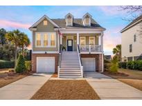 Charming two-story home featuring double garages, inviting porch, and classic American architectural details at 158 Sandshell Dr, Charleston, SC 29492