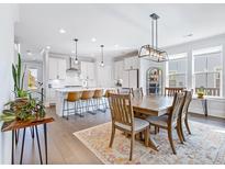 Bright dining area with a wooden table set on an ornate rug, lit by a modern light fixture at 170 Callibluff Dr, Summerville, SC 29486