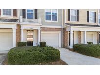 Charming townhouse exterior with brick accents, manicured bushes, and private garage at 264 Fair Sailing Rd # 42, Mount Pleasant, SC 29466