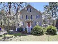 Charming two-story home with blue shutters, a red door, and mature trees providing shade at 3651 Barton St, Johns Island, SC 29455