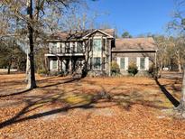 Charming two-story brick home with a balcony and landscaped yard surrounded by trees at 388 Benton Farm Rd, Walterboro, SC 29488