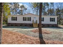 Well-maintained white single-story home with black shutters, wooden steps, and a freshly mulched yard at 421 Peacock Ln, Summerville, SC 29486
