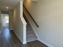 Bright entryway showcasing a carpeted staircase with gray walls and wood-look flooring at 5118 Double Eagle Lp, Summerville, SC 29485