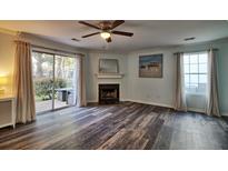 Bright living room featuring a fireplace, ceiling fan and sliding glass door to outdoor space at 6211 Rolling Fork Rd. # 1504 Apt D, North Charleston, SC 29406