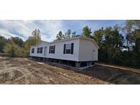 Newly constructed single story home featuring white siding, black shutters, and a well maintained lawn at 635 Dennis Ridge Rd, Bonneau, SC 29431