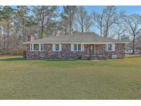 Charming brick ranch-style home with a well-manicured lawn and mature trees, offering classic curb appeal at 1186 French Santee Rd, Jamestown, SC 29453