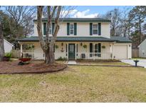 Charming two-story home featuring a welcoming front porch with green shutters and complemented by mature trees at 159 Bridgecreek Dr, Goose Creek, SC 29445