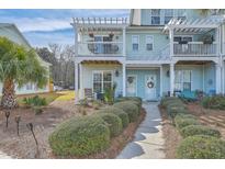 Charming coastal townhome featuring a private balcony and well-maintained landscaping with inviting walkway at 1717 Brittlebush Ln, Johns Island, SC 29455