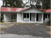 Charming one-story home featuring a red metal roof, white painted brick, and a convenient carport at 201 Hayden St St, Walterboro, SC 29488