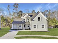 Charming two-story home with a well-manicured lawn, long driveway, and inviting covered porch at 213 Cherry Grove Dr, Summerville, SC 29483