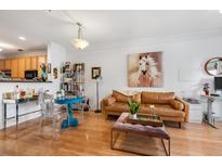 Bright living room features hardwood floors, a tan leather sofa, and an open floor plan at 2244 Ashley Crossing Dr # 426, Charleston, SC 29414