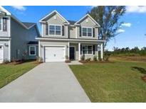 Charming two-story home with a well-manicured lawn and attached garage at 320 Abercom Place Dr, Moncks Corner, SC 29461