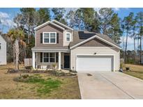 Charming two-story home with a two car garage, manicured lawn, and solar panels on the roof at 324 Spruce Ivy St, Moncks Corner, SC 29461