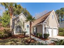 Charming home featuring mature landscaping, a well-manicured lawn, and a welcoming entrance with a light green door at 412 Vinca, Mount Pleasant, SC 29464
