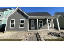 Charming single-story home with gray siding, white trim, covered front porch, and well-maintained landscaping at 442 Ripple Park Dr, Summerville, SC 29486