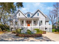 Stately two-story home featuring a welcoming front porch, beautiful landscaping, and a circular driveway at 939 White Point Blvd, Charleston, SC 29412