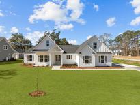 Charming new construction featuring white siding, a well-manicured lawn, and inviting curb appeal at 00 N Highway 17, McClellanville, SC 29458