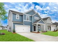 Charming two-story home boasts a blue exterior, attached garage, and manicured lawn at 1035 Swamp Rose Run, Summerville, SC 29485