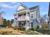 Charming two-story home featuring a quaint porch, a well-manicured lawn, and attractive curb appeal at 1070 Moss Grove Dr, Moncks Corner, SC 29461