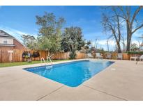 Backyard swimming pool with blue water, concrete patio, and chairs, surrounded by a wooden fence at 117 Swan Dr, Summerville, SC 29485