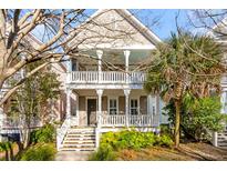 Charming two-story home with a welcoming front porch and upper level balcony, enhanced by mature trees and lush greenery at 1331 Appling Dr, Mount Pleasant, SC 29464