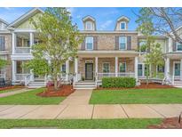 Charming two-story brick townhome with a cozy front porch and manicured lawn in a desirable community at 1399 Tollison Path, Mount Pleasant, SC 29466