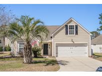 Inviting single-Gathering home featuring an attached garage, manicured lawn, and a palm tree at 1465 Water Edge Dr, Charleston, SC 29492