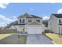 Charming two-story home with a well-manicured lawn, inviting front porch, and attached two-car garage at 200 Short Woods Ct, Summerville, SC 29486