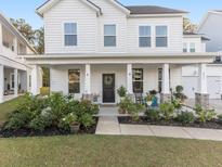 Charming front porch with rocking chair, lush plants, and welcoming curb appeal at 217 Woodland Oak Way, Summerville, SC 29485
